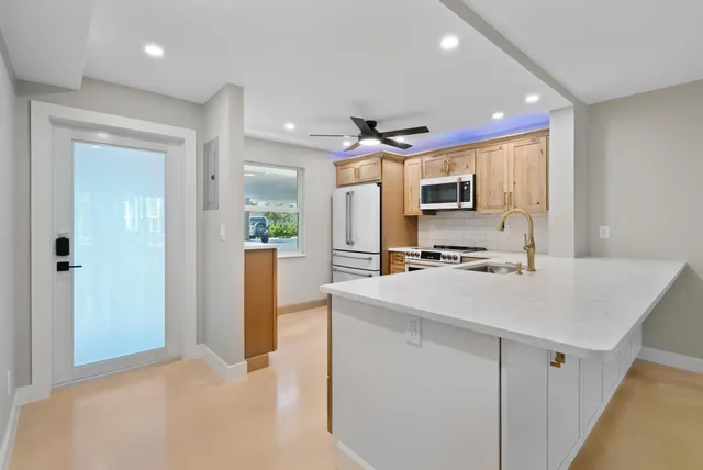 a kitchen with stainless steel appliances a stove a microwave and white cabinets
