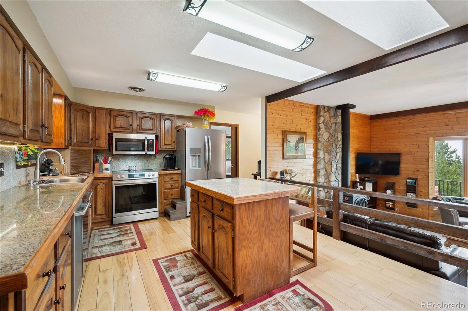 11094 Thomas Drive Conifer, CO 80433 - Photo 11 of 44 a kitchen with a stove a sink dishwasher a refrigerator and a oven with wooden floor