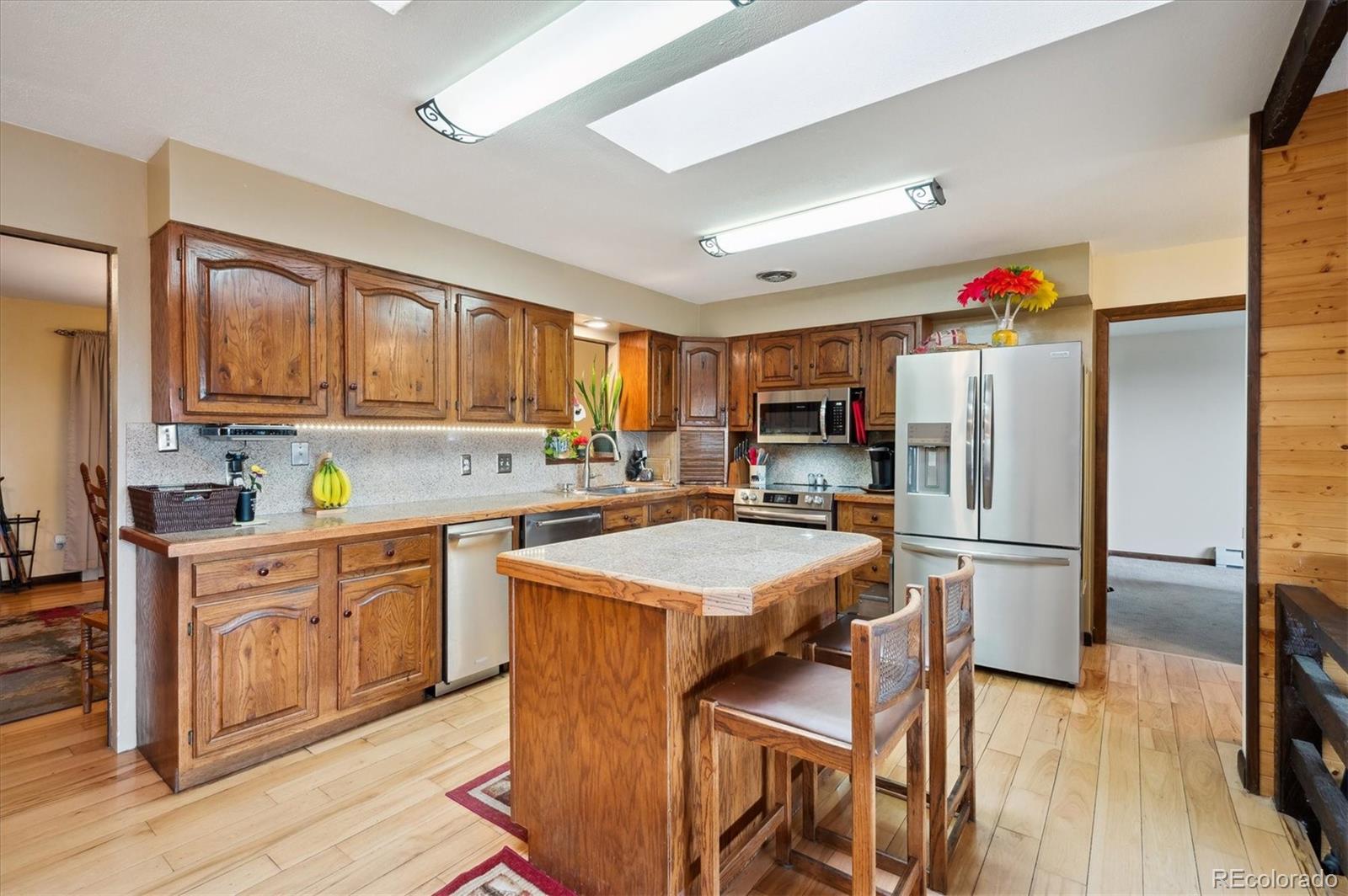 11094 Thomas Drive Conifer, CO 80433 - Photo 12 of 44 a kitchen with granite countertop a refrigerator stove top oven and sink