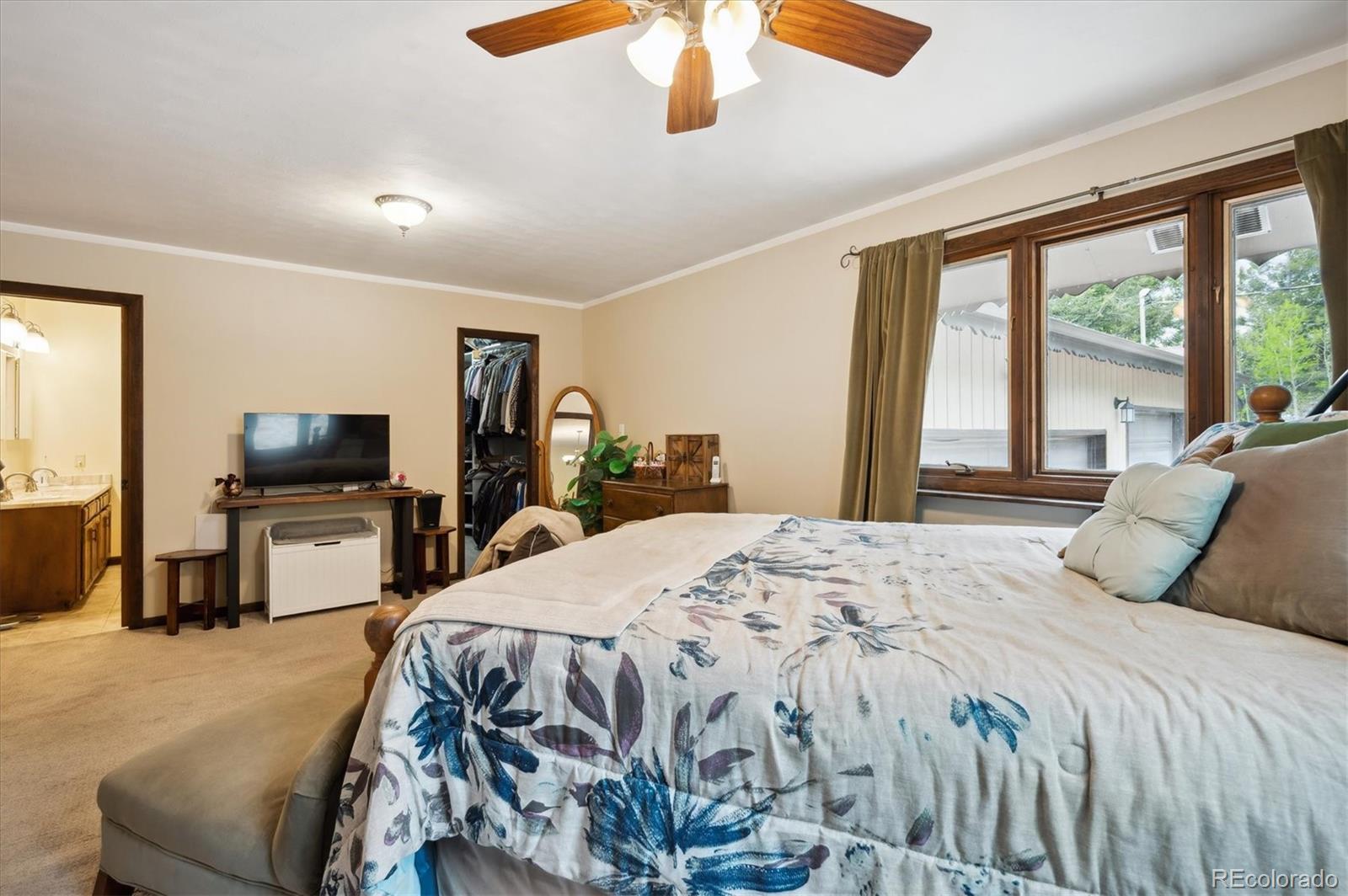 11094 Thomas Drive Conifer, CO 80433 - Photo 19 of 44 a bedroom with a bed and a flat screen tv