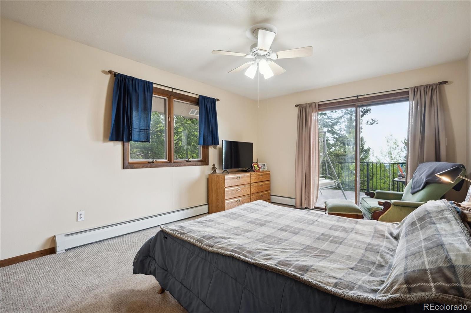 11094 Thomas Drive Conifer, CO 80433 - Photo 21 of 44 a bedroom with a large bed and a flat tv screen on dresser