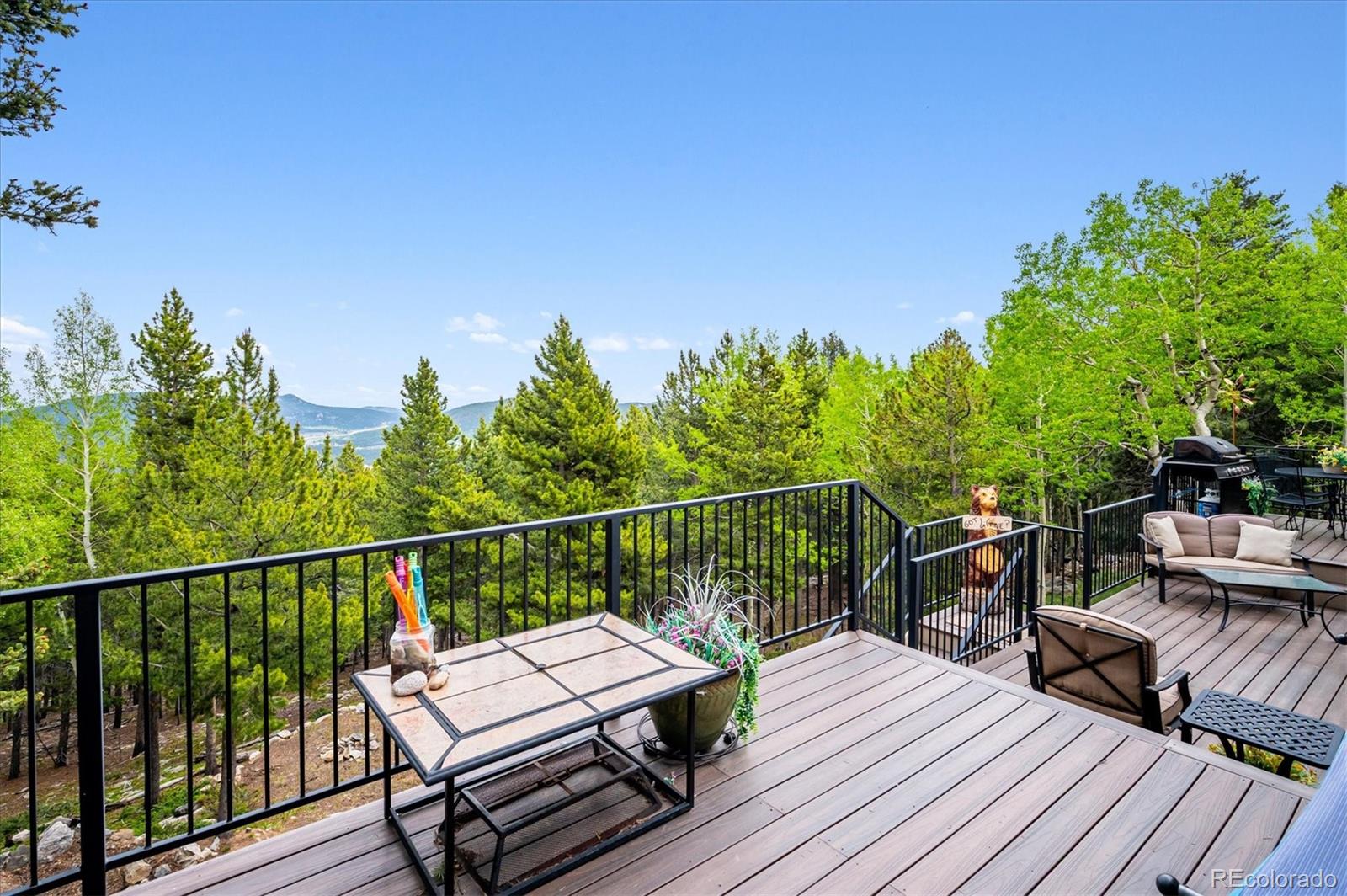 11094 Thomas Drive Conifer, CO 80433 - Photo 4 of 44 a view of a balcony with wooden floor and outdoor seating
