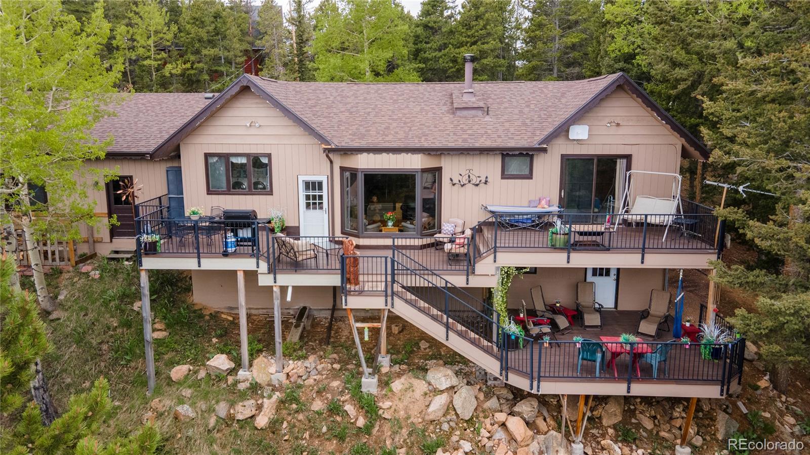 11094 Thomas Drive Conifer, CO 80433 - Photo 7 of 44 a view of house with outdoor seating area and trees