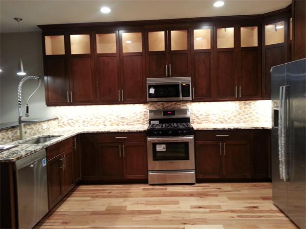 a kitchen with kitchen island granite countertop a stove wooden cabinets and a sink