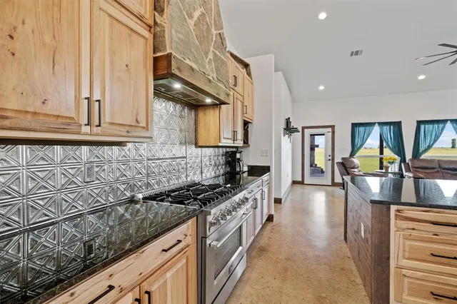 a kitchen with stainless steel appliances granite countertop a stove a sink and a refrigerator