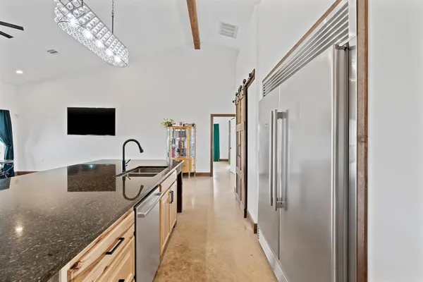 a kitchen with stainless steel appliances granite countertop a sink and a refrigerator