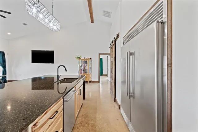 a kitchen with stainless steel appliances granite countertop a sink and a refrigerator