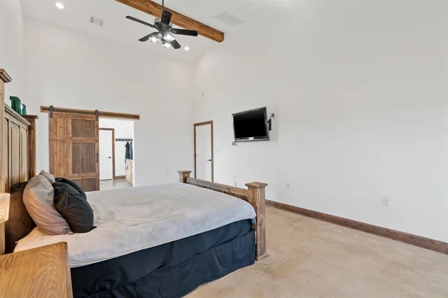 a bedroom with a bed and a flat tv screen on the dresser