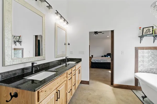 a en suite bathroom with a granite countertop sink and a mirror