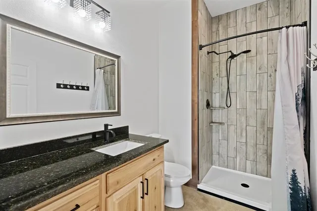a bathroom with a granite countertop sink mirror and shower