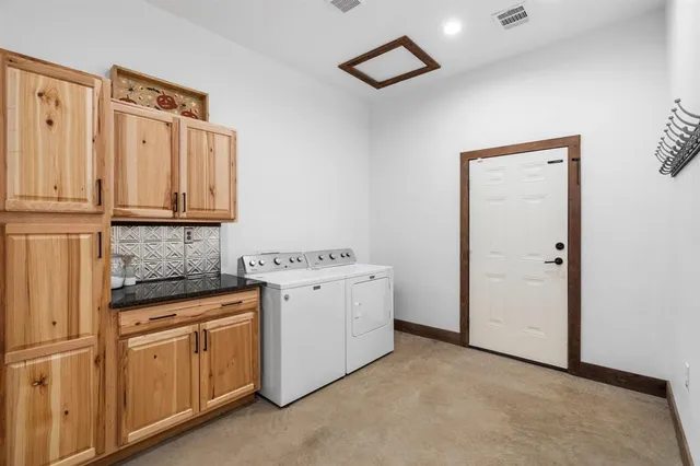 a utility room with cabinets washer and dryer