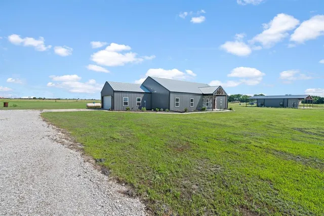 a view of a house with a big yard and a large tree