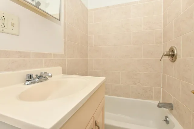 a bath tub sitting next to a white sink
