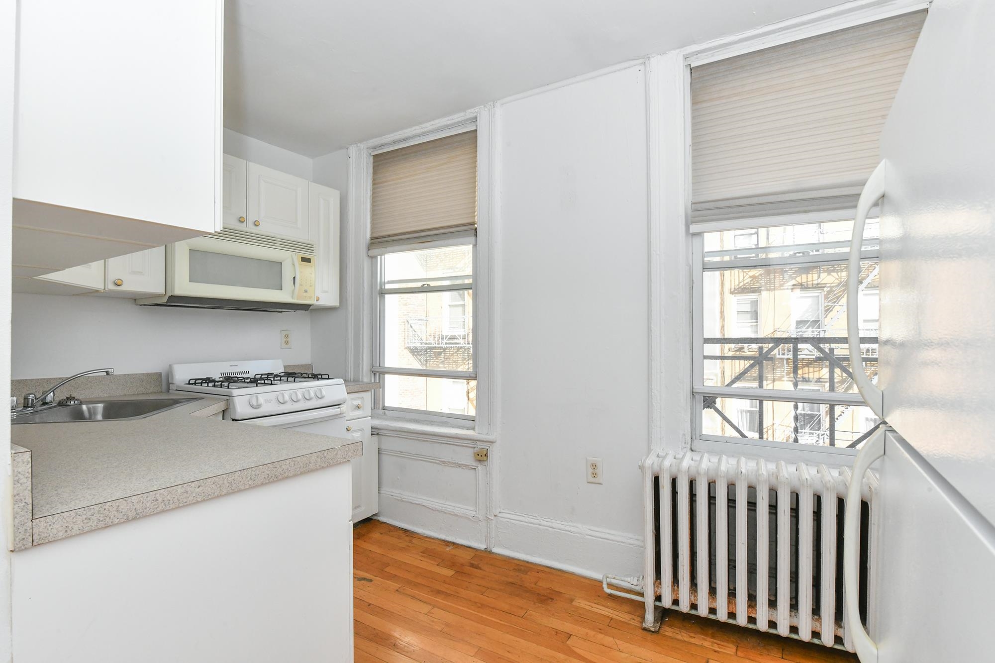 409 Bloomfield Street, Unit 7 Hoboken, NJ 07030 - Photo 3 of 14 a kitchen with stainless steel appliances granite countertop a stove and a window