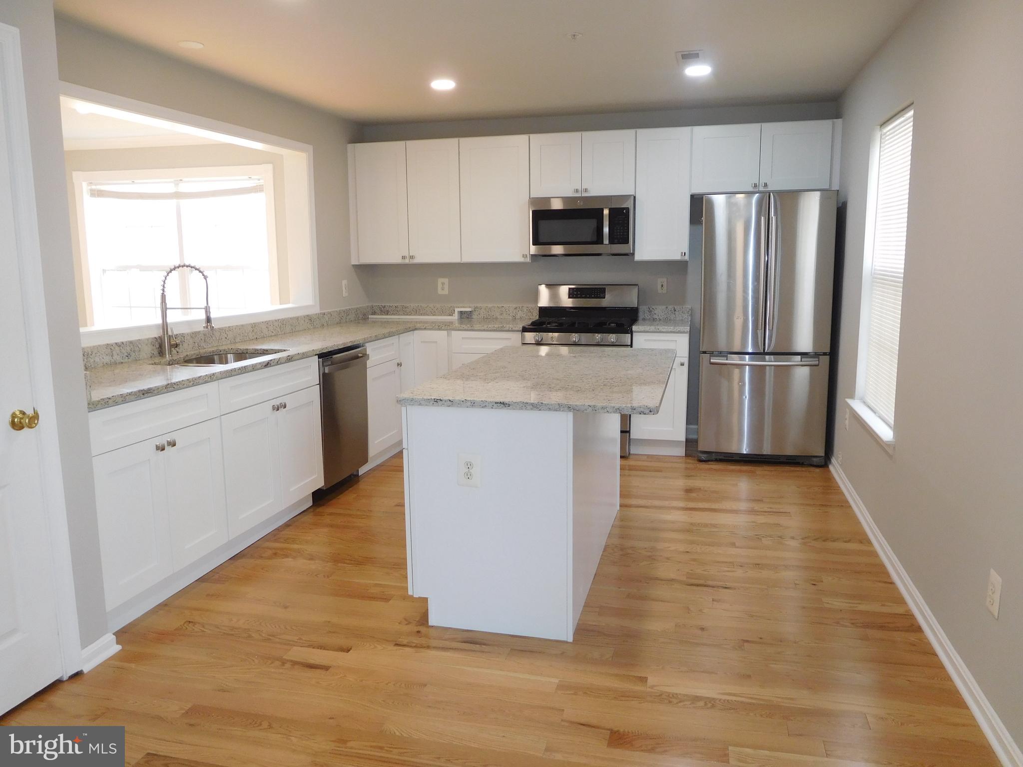 9900 Doubletree Lane Bowie, MD 20721 - Photo 2 of 18 a kitchen with a sink a refrigerator a microwave and cabinets
