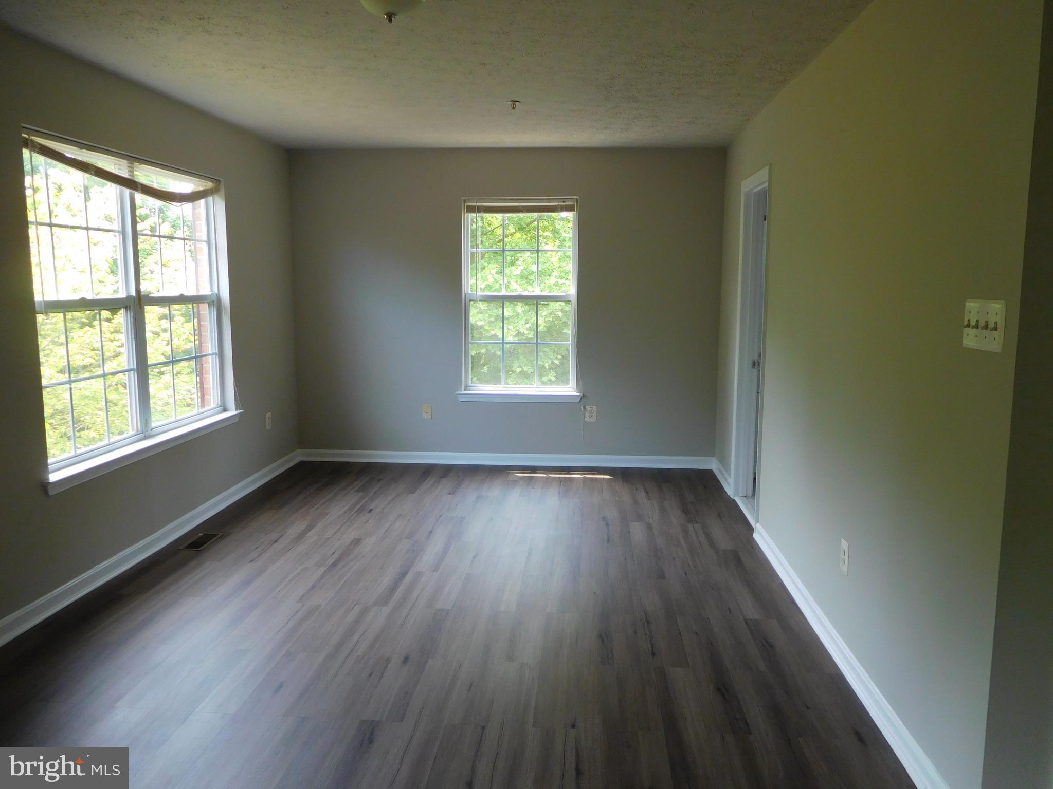 9900 Doubletree Lane Bowie, MD 20721 - Photo 7 of 18 a view of an empty room with wooden floor and window