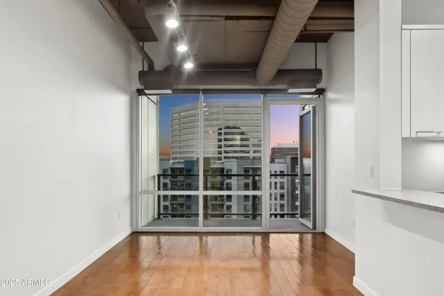 a kitchen with stainless steel appliances granite countertop a refrigerator a sink a stove and white cabinets with wooden floor