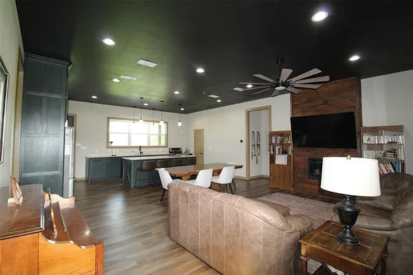a living room with stainless steel appliances furniture and a kitchen view
