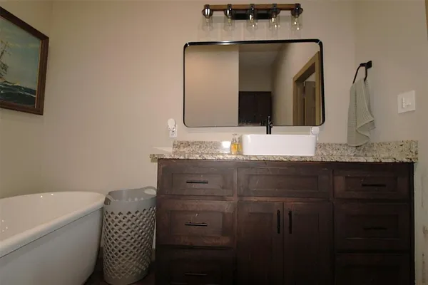 a bathroom with a granite countertop sink a toilet and mirror