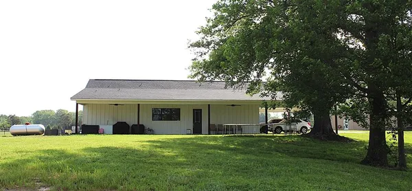 a view of a house with backyard and a tree