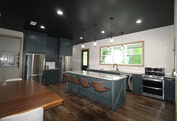 a large kitchen with kitchen island a sink stove and refrigerator