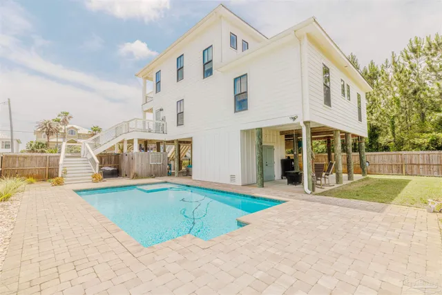 a view of a white house with a big yard and large trees
