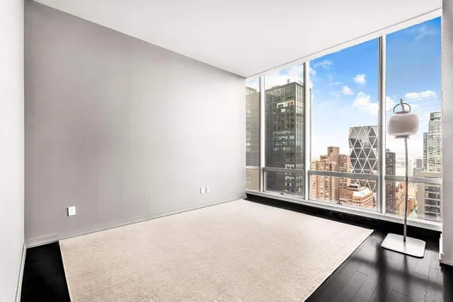 a view of a room with floor to ceiling window and wooden floor