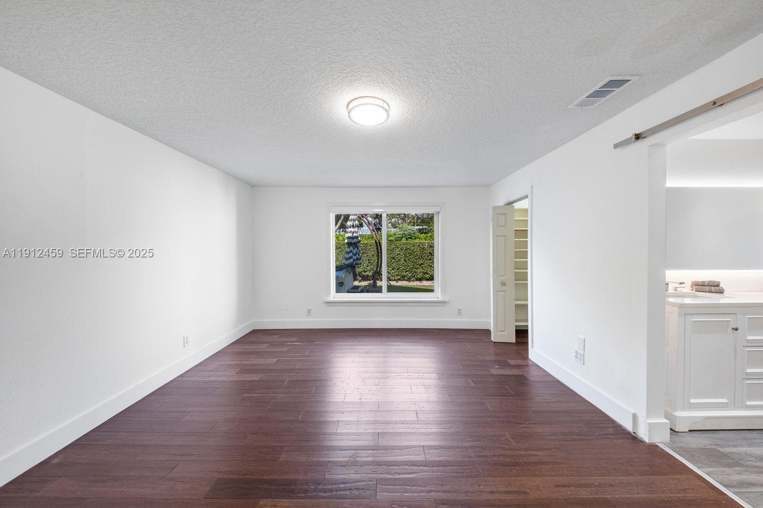 10025 Southwest 83rd Street Miami, FL 33173 - Photo 15 of 37 a view of an empty room with wooden floor and a window