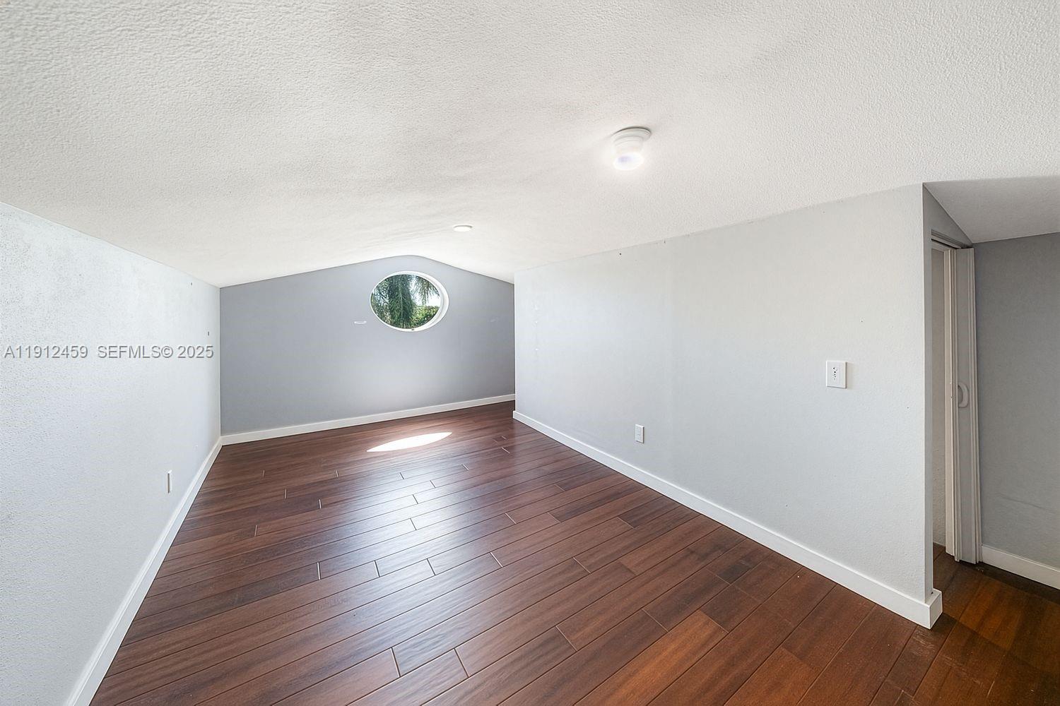 10025 Southwest 83rd Street Miami, FL 33173 - Photo 22 of 37 a view of an empty room with wooden floor