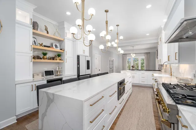 a dining room with wooden floor a chandelier a glass table and chairs