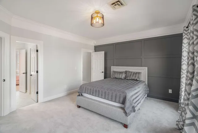 a spacious bedroom with a bed and a chandelier