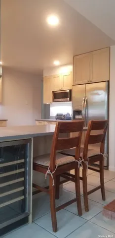 a room with a table chairs and a refrigerator