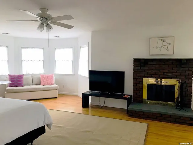 a living room with furniture a flat screen tv and a fireplace