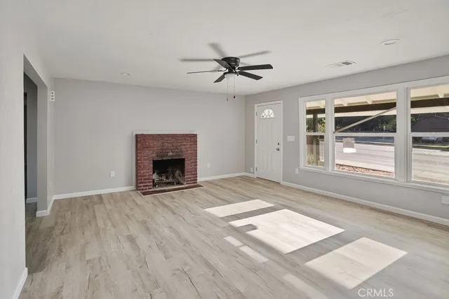 an empty room with windows and fireplace