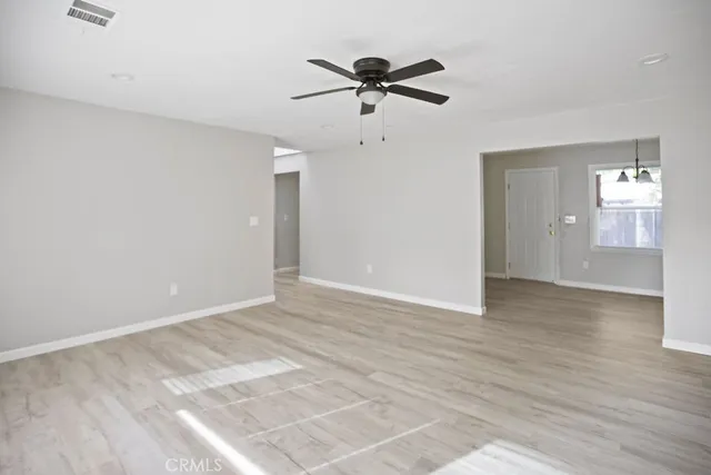 a view of a livingroom with a ceiling fan & hardwood floor