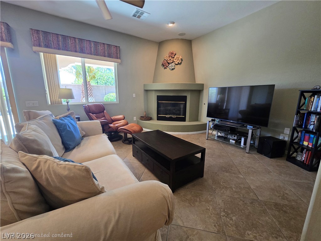2567 Dirleton Place Henderson, NV 89044 - Photo 22 of 67 A well-lit living area showcases a corner fireplace and ample space for relaxation.