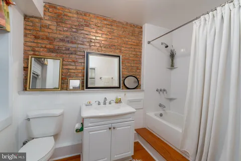 a view of a roof deck with table and chairs under an umbrella with wooden floor