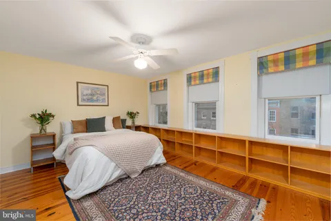 a view of a roof deck with table and chairs under an umbrella with wooden floor