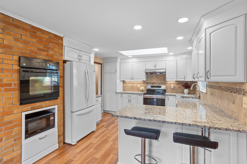 10 Lincoln Drive Acton, MA 01720 - Photo 3 of 32 a kitchen with granite countertop a stove refrigerator and microwave