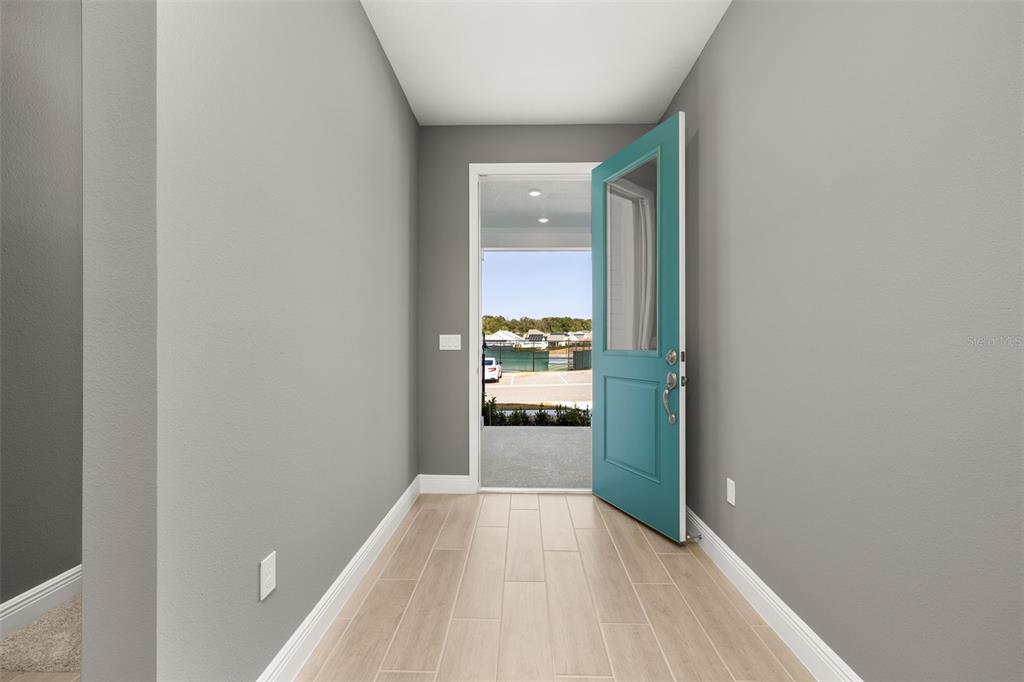 985 Fiesta Key Circle Lady Lake, FL 32159 - Photo 3 of 34 a view of a hallway to a livingroom and a bathroom with sink