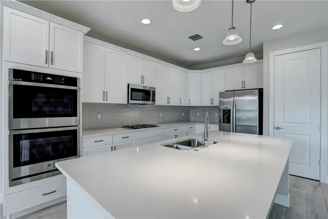 a kitchen with kitchen island a stove a sink and a refrigerator