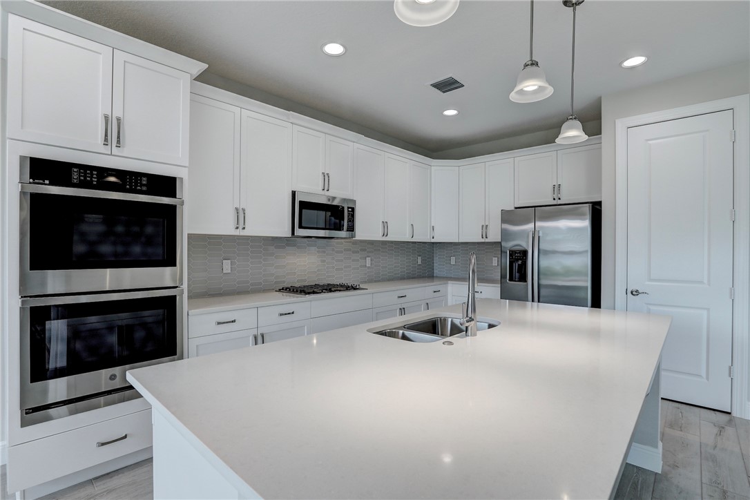 6423 High Pointe Circle Vero Beach, FL 32967 - Photo 16 of 36 a kitchen with kitchen island a stove a sink and a refrigerator