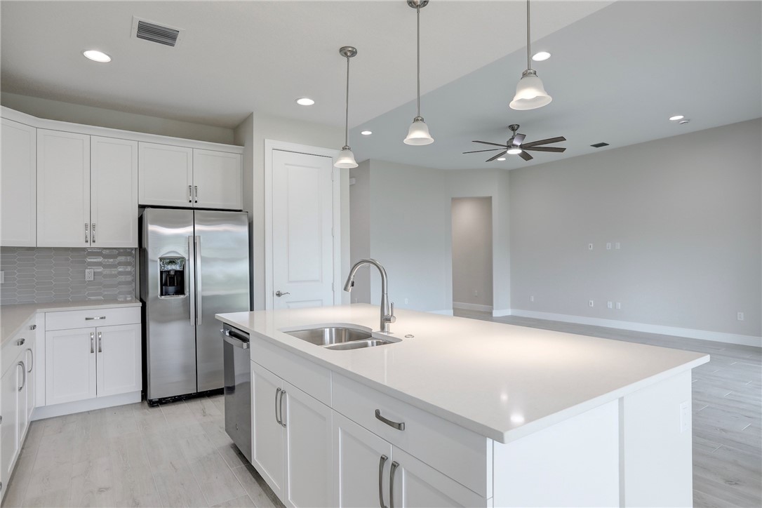 6423 High Pointe Circle Vero Beach, FL 32967 - Photo 17 of 36 a kitchen with stainless steel appliances a refrigerator sink and white cabinets
