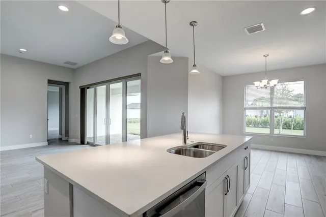 a kitchen with a sink a center island and a wooden floor