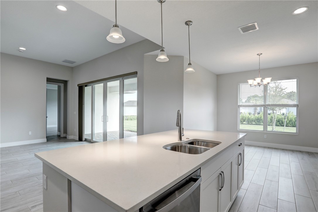 6423 High Pointe Circle Vero Beach, FL 32967 - Photo 18 of 36 a kitchen with a sink a center island and a wooden floor
