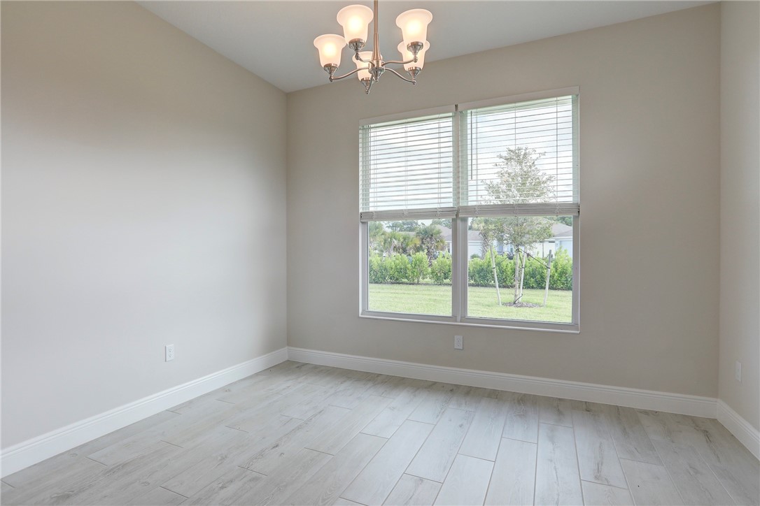 6423 High Pointe Circle Vero Beach, FL 32967 - Photo 21 of 36 an empty room with wooden floor and windows