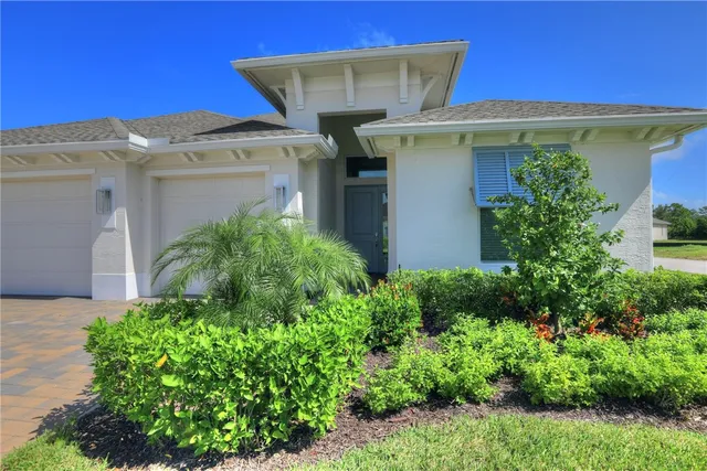 a front view of a house with plants