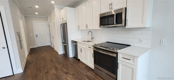 a kitchen with stainless steel appliances a stove microwave and refrigerator