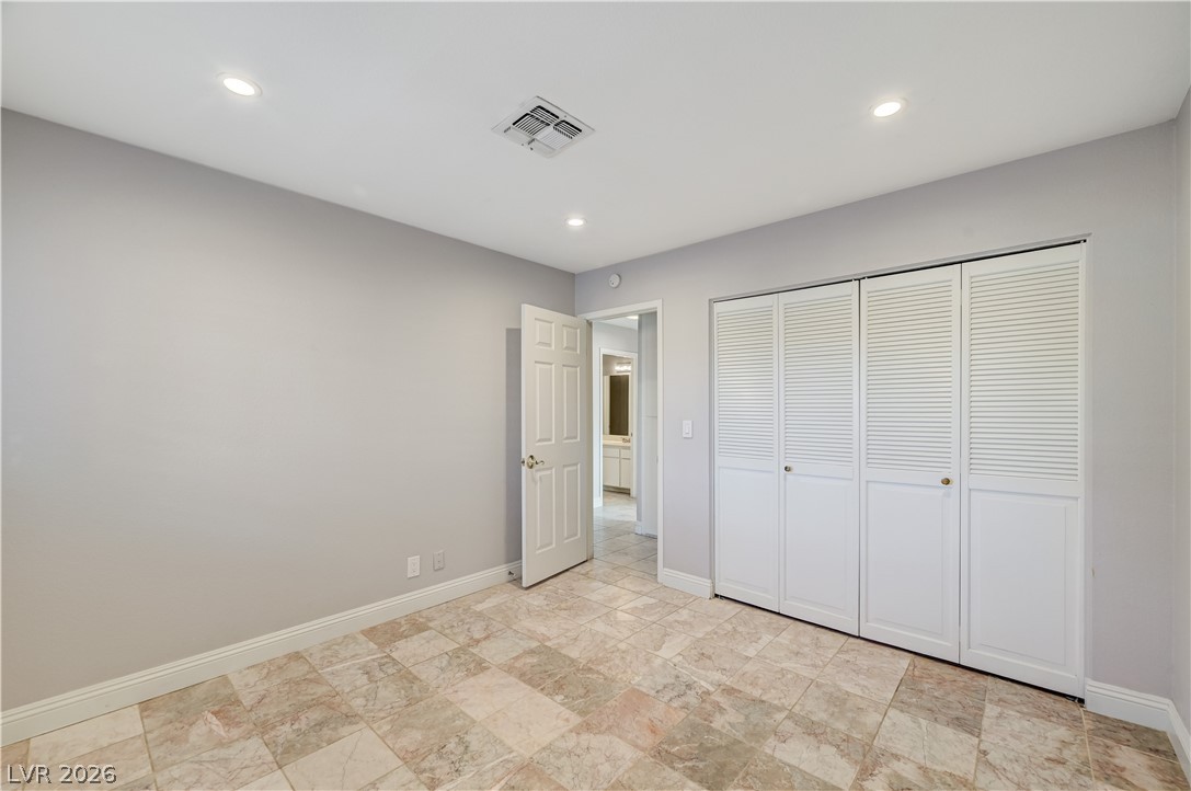 6635 Costa Brava Road Las Vegas, NV 89146 - Photo 48 of 59 A well-lit bedroom features durable tile flooring and convenient louvered closet doors.