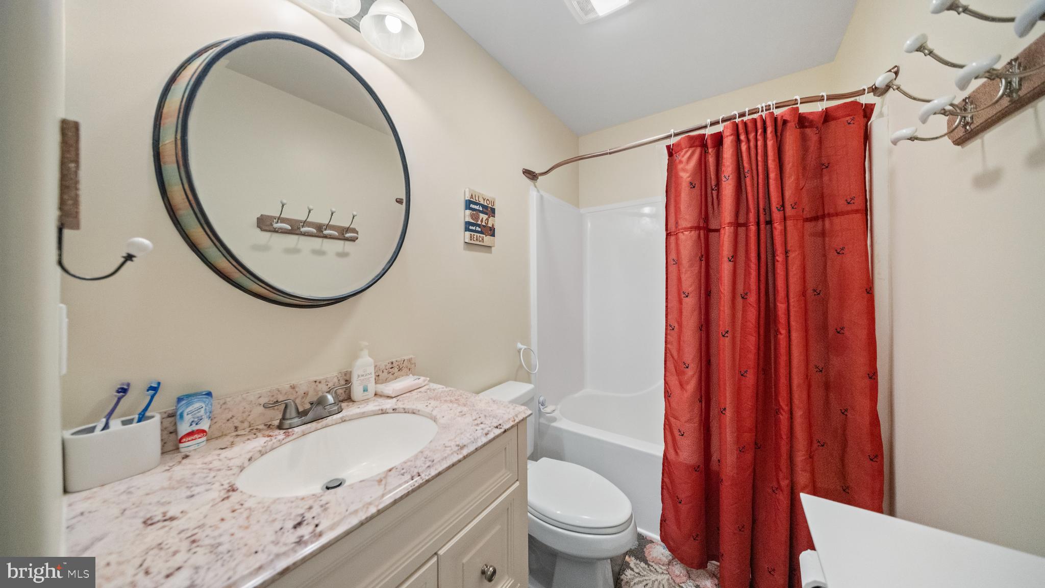 128 Sandyhook Road Ocean Pines, MD 21811 - Photo 20 of 37 a bathroom with a sink a toilet and a mirror